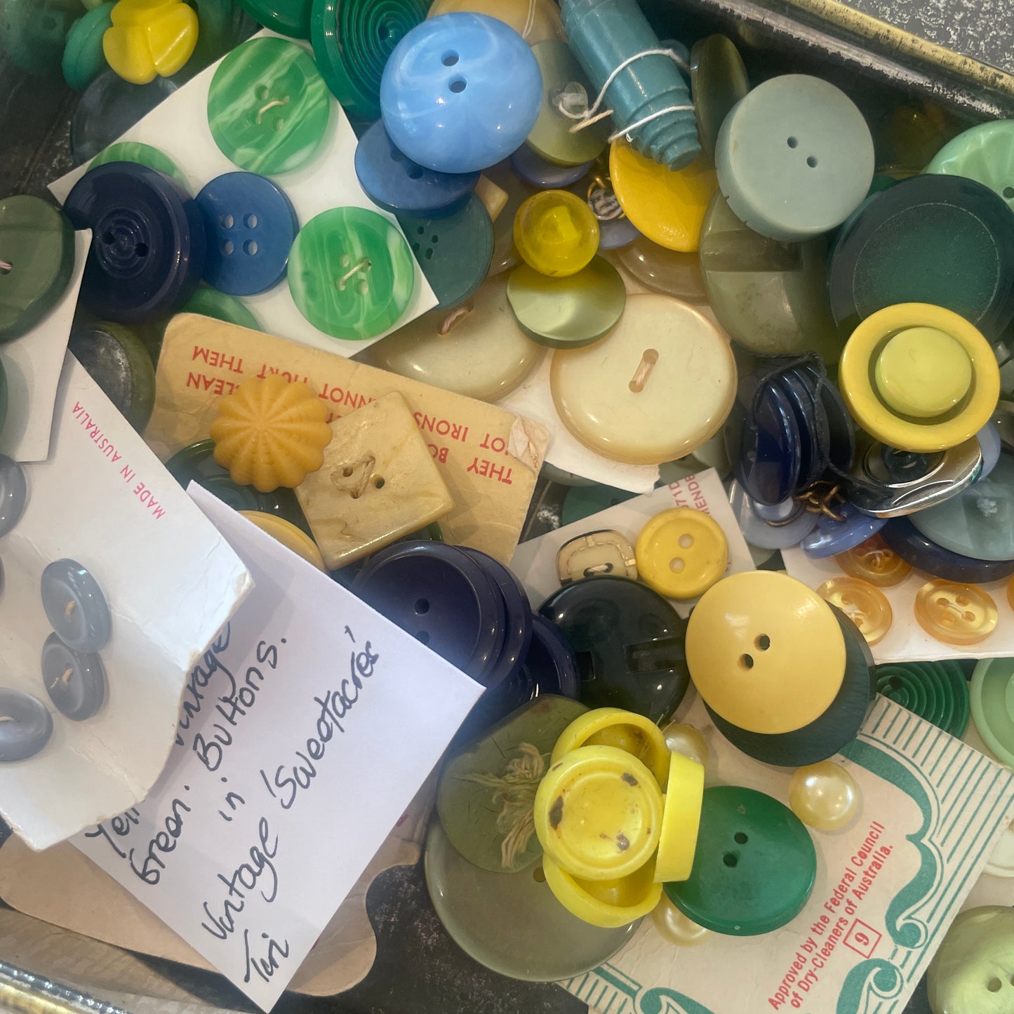 vintage sweetscres tin filled with vintage buttons in blues and greens