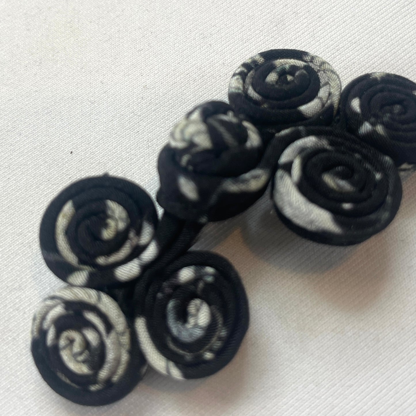 black and white print coiled frog closure