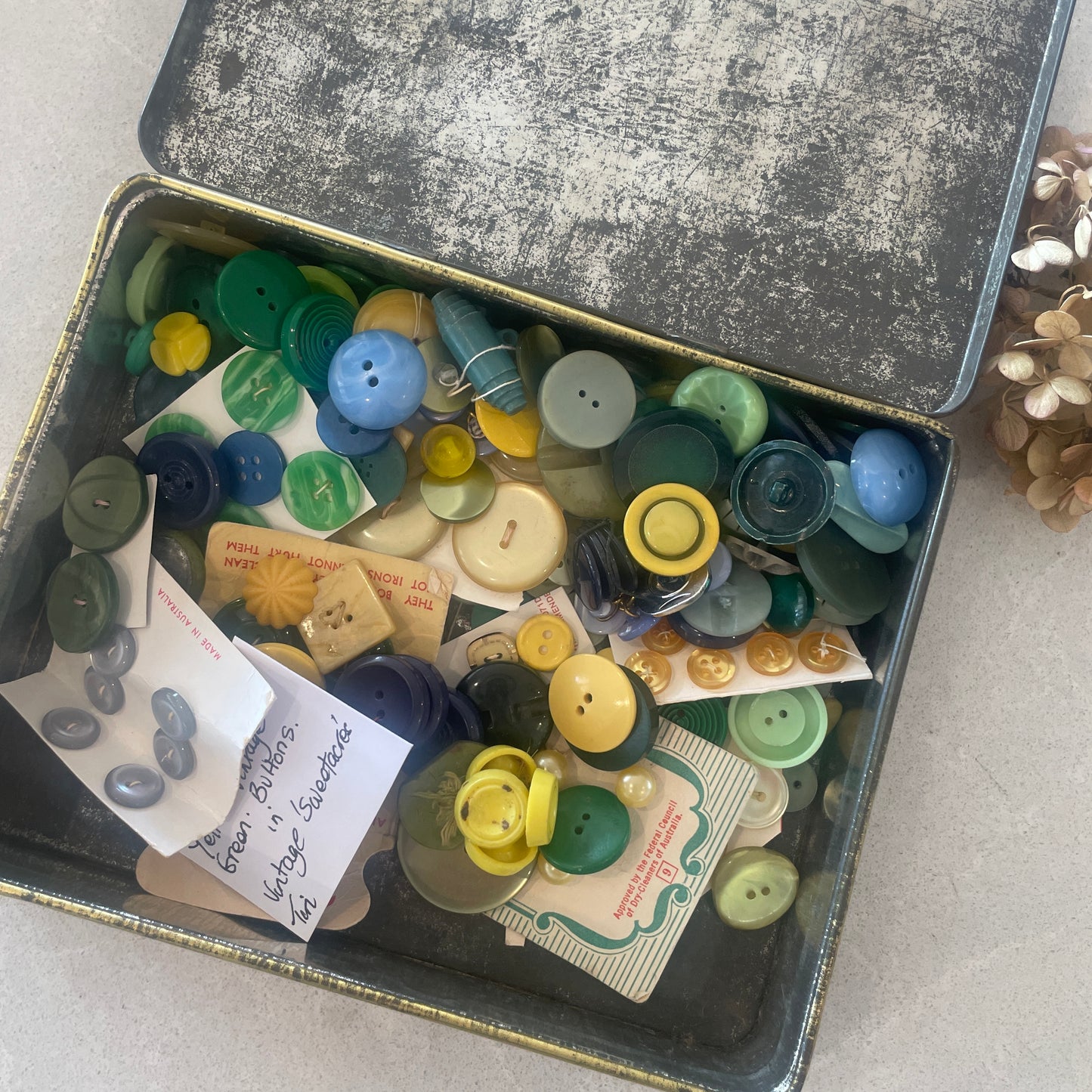 vintage sweetscres tin filled with vintage buttons in blues and greens